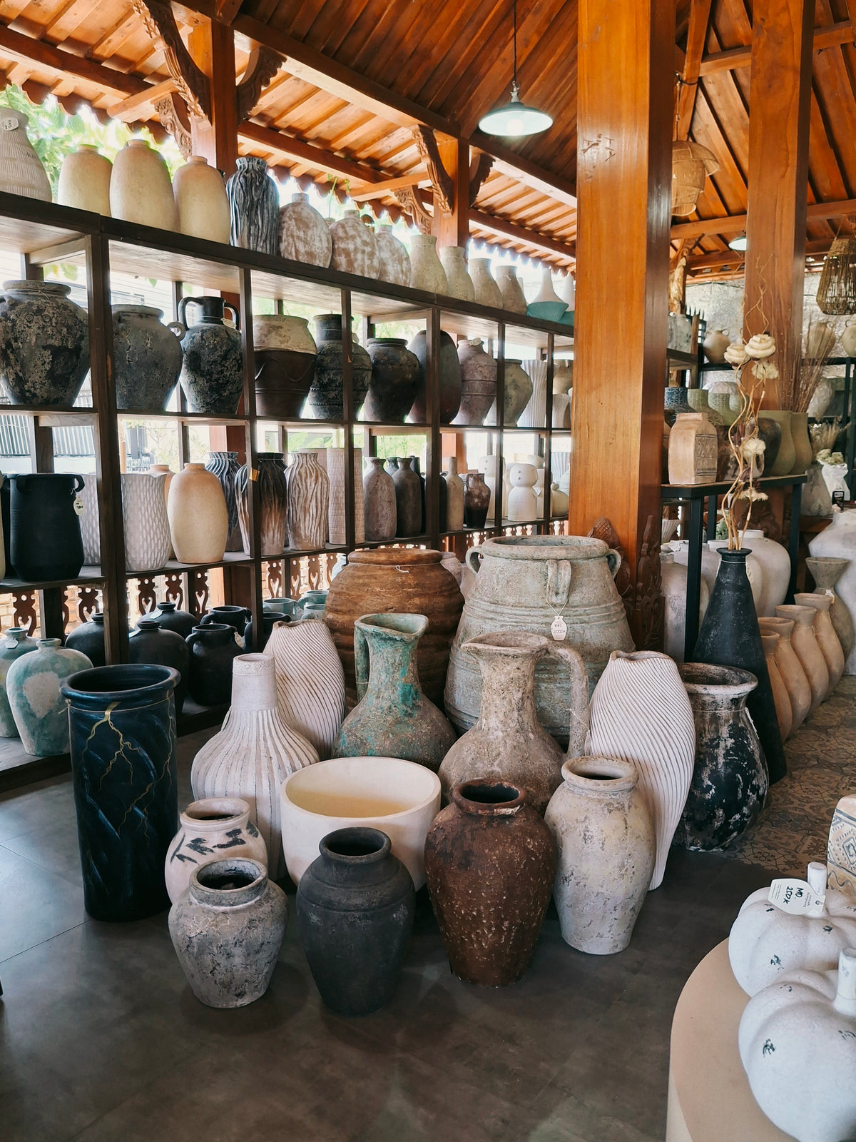Shelves of handmade terracotta pottery inside the joglo showroom