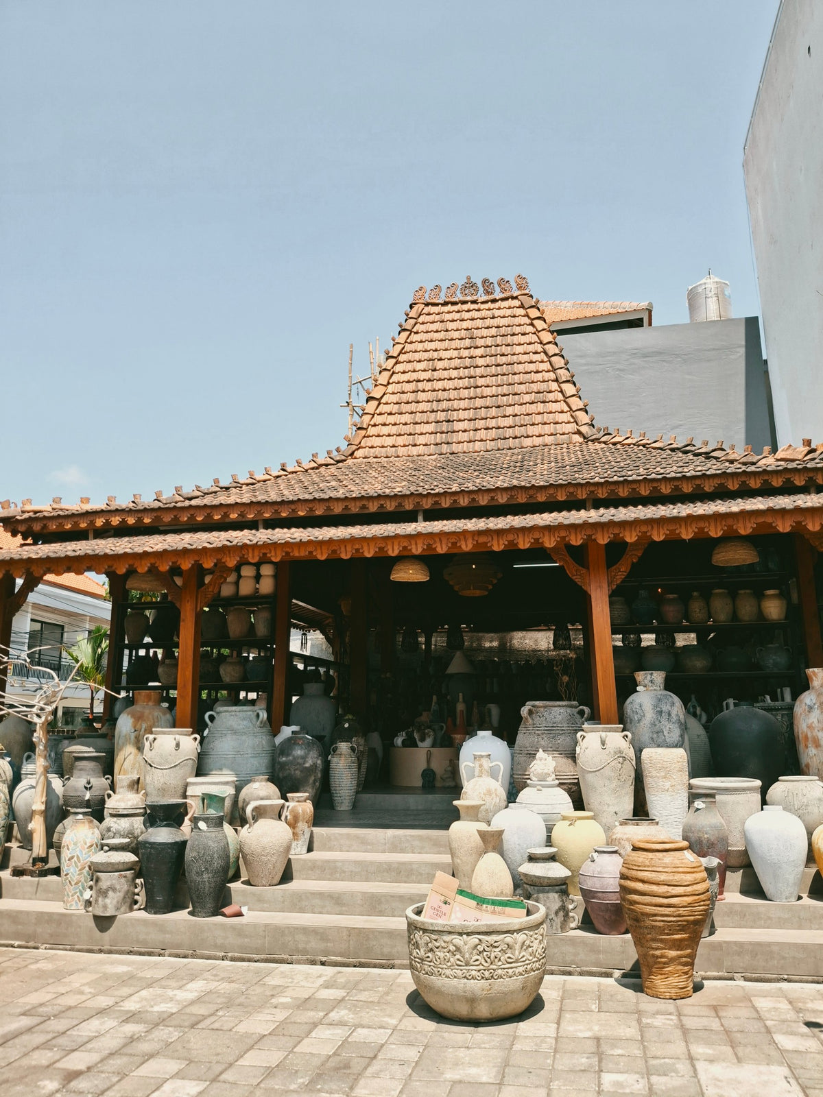 The Omah Lempung joglo showroom in Kerobokan, Bali, with terracotta pottery on its steps